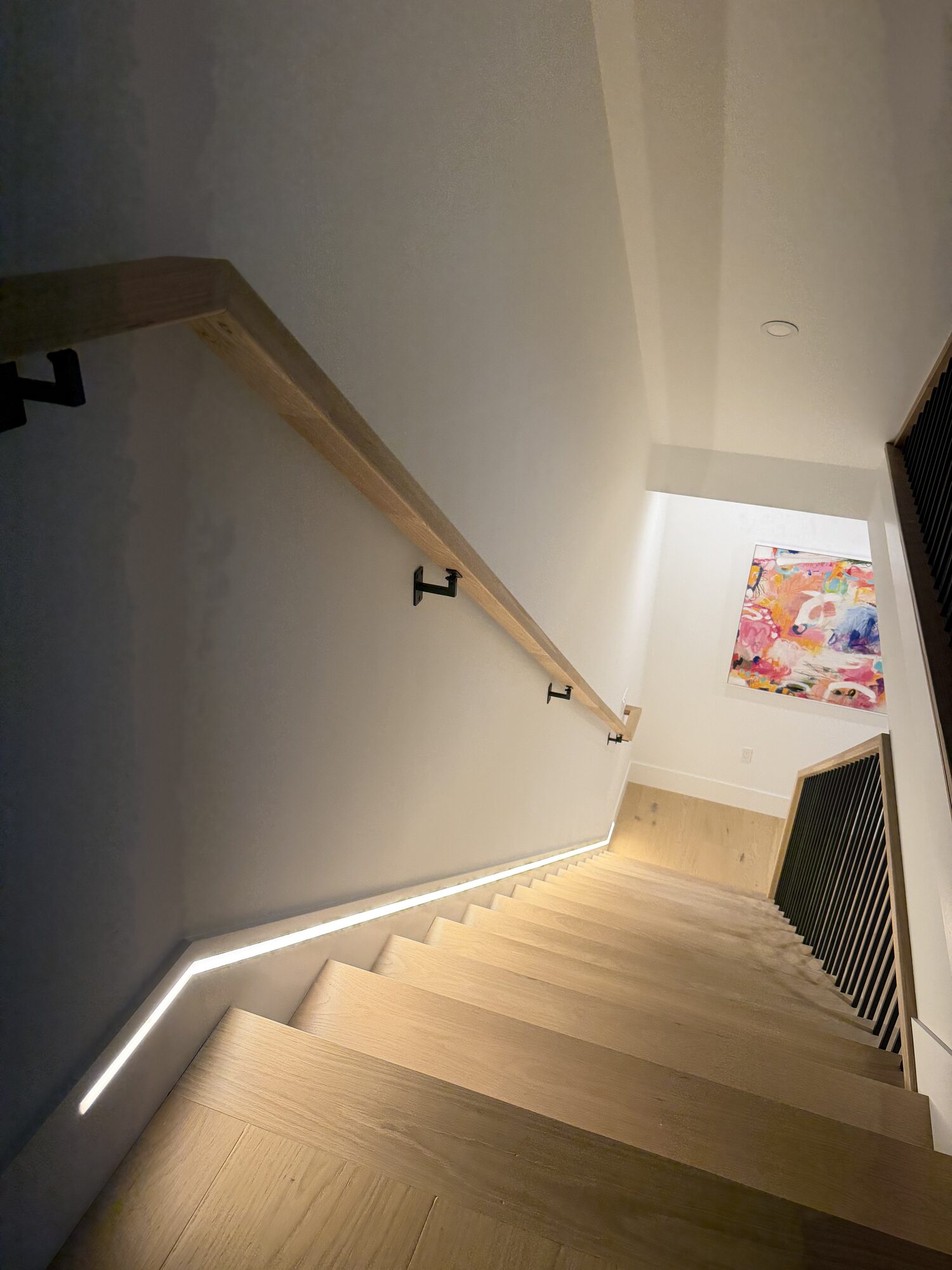 Finished stair with LED runner lighting looking toward hung abstract artwork at 421 East Sixth Street, Residence 4, South Boston