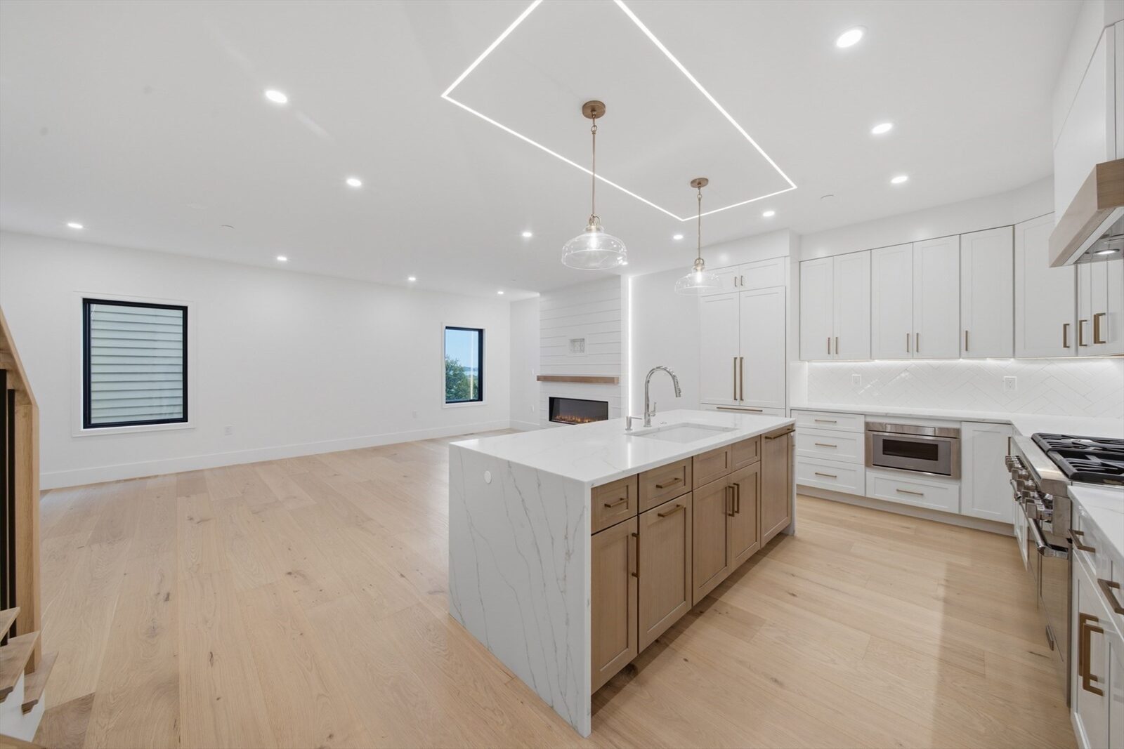 Open kitchen and living with island and fireplace at 421 East Sixth Street, Residence 3