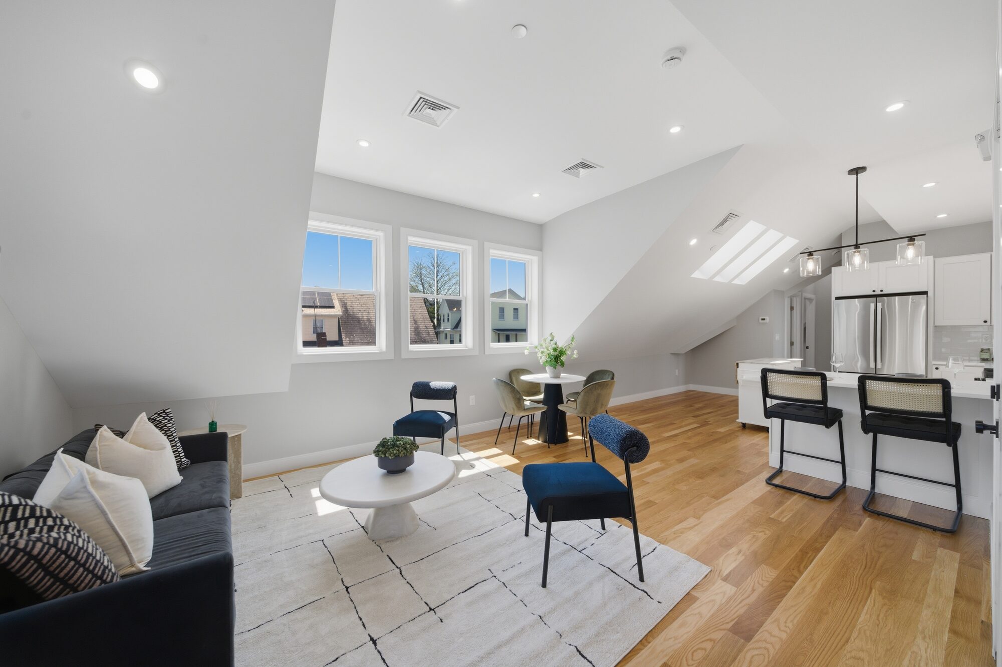 Open living, kitchen, and dining with sofa, island, and skylight at 174 Walnut Street, Unit 3