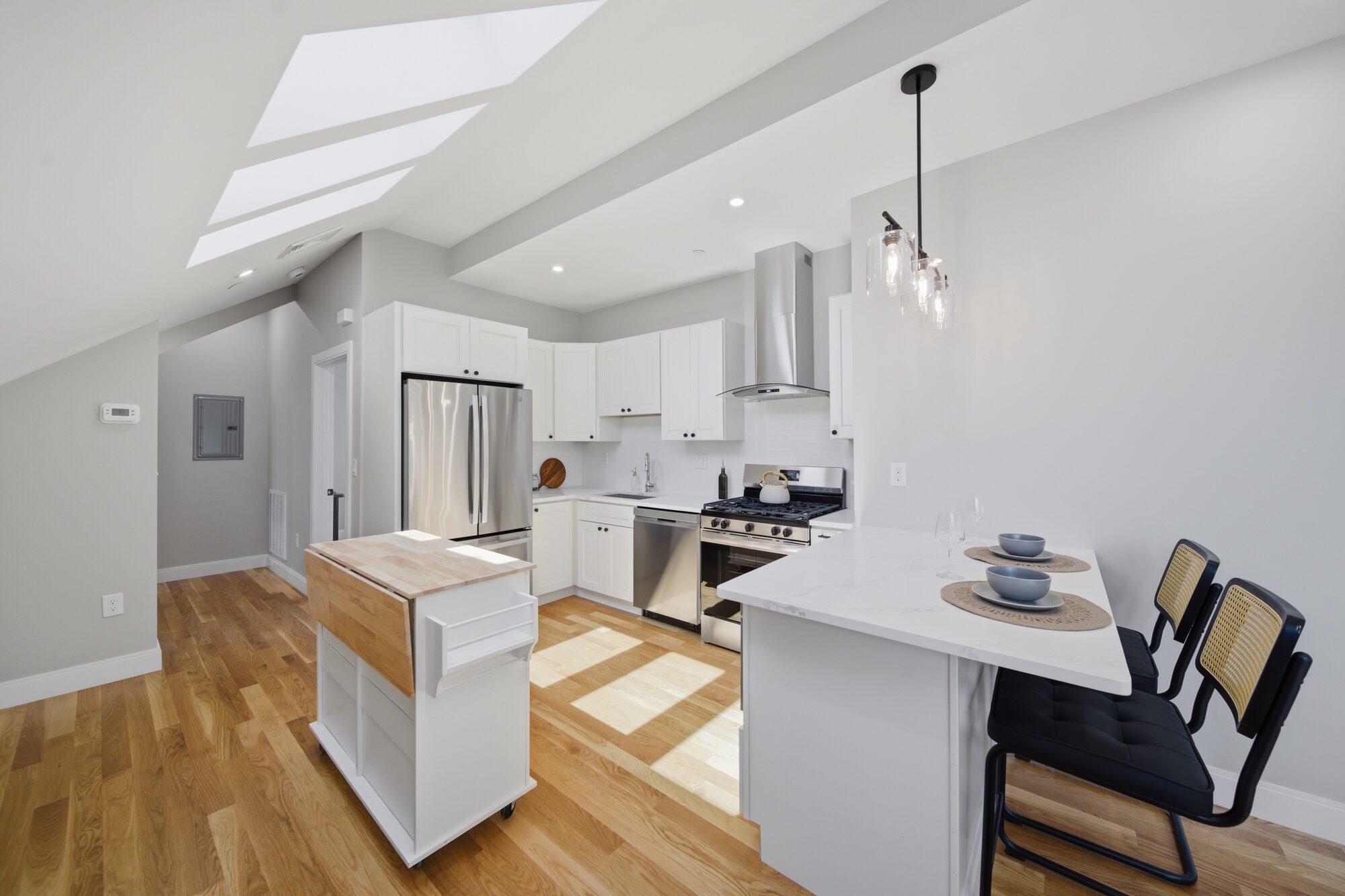 Kitchen with white cabinets, stainless appliances, and a skylight at 174 Walnut Street, Unit 3