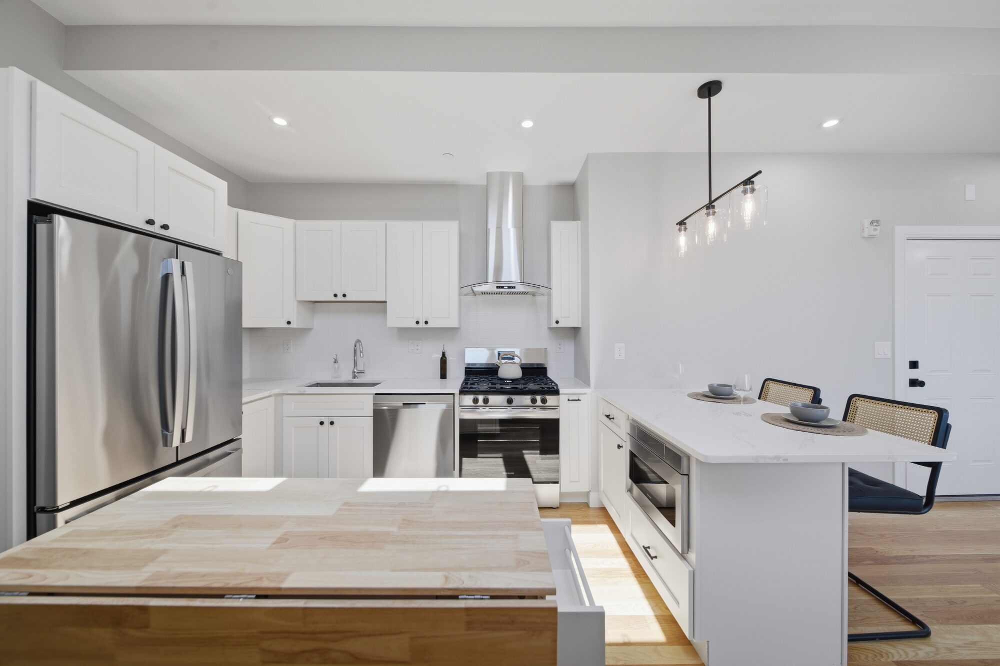 Kitchen breakfast bar and peninsula with pendant light at 174 Walnut Street, Unit 3