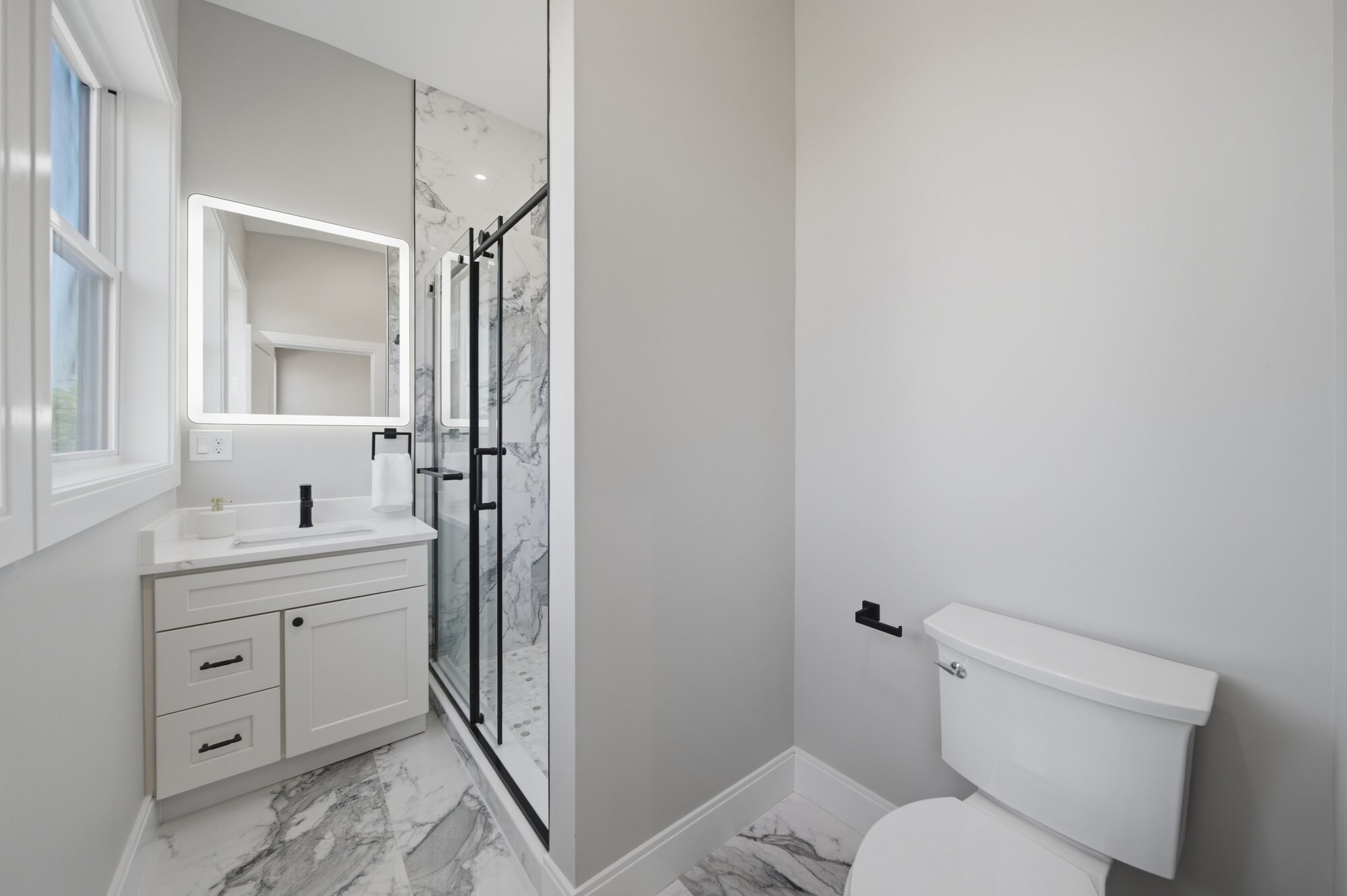Bathroom with vanity, LED mirror, and black-framed glass shower at 174 Walnut Street, Unit 3