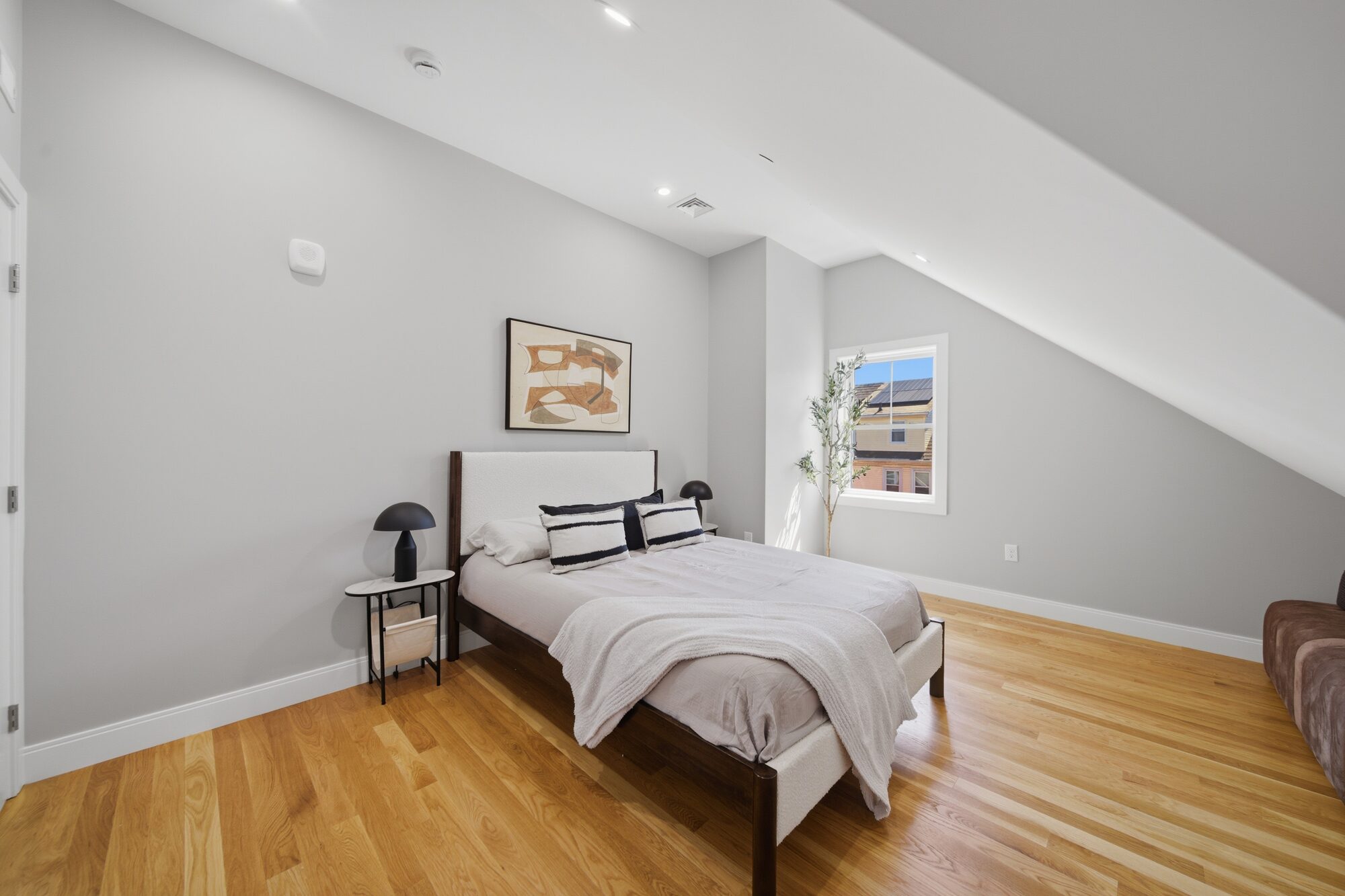 Bedroom 2 with sloped ceiling, bed, and window at 174 Walnut Street, Unit 3
