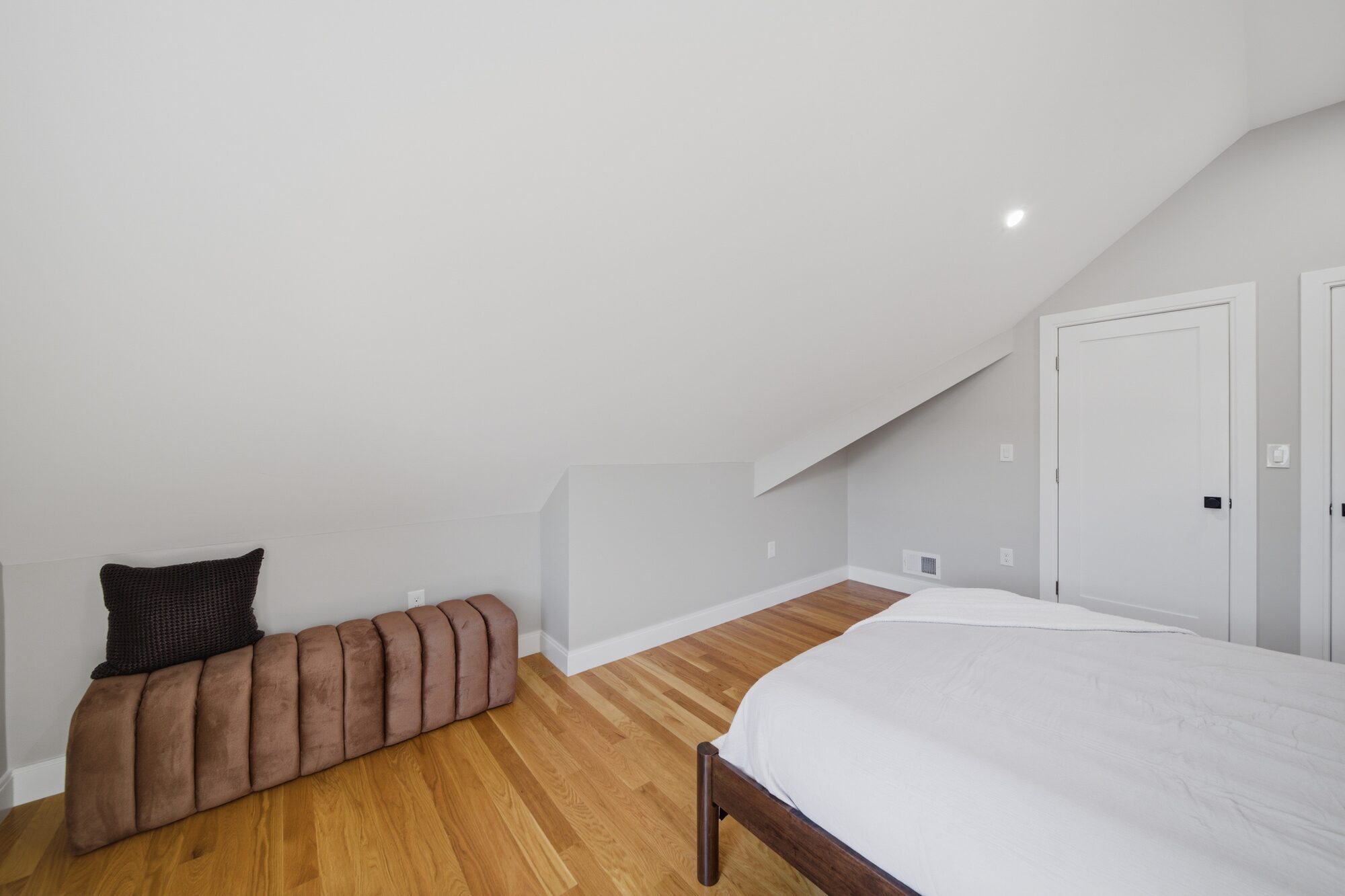 Bedroom 2 under the eaves with bench and closet doors at 174 Walnut Street, Unit 3